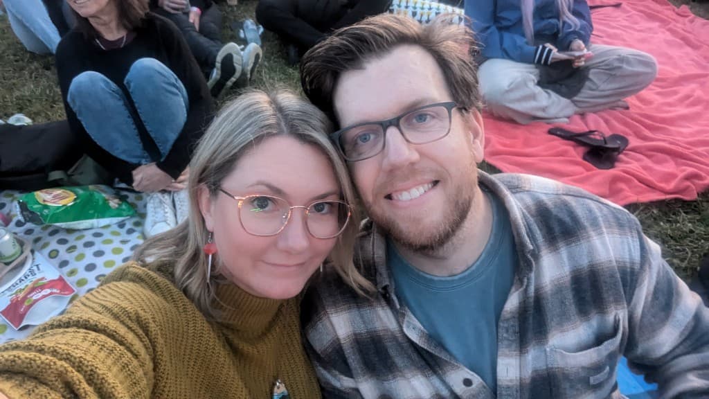 Leigh and Tom sitting together on a picnic blanket in Melbourne